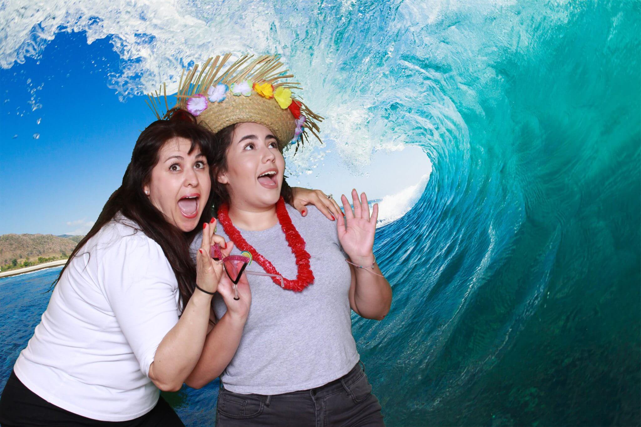 Girls in front of green screen photo booth ocean wave